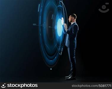 business, people and technology concept - businessman in suit working with virtual projection over black background. businessman with virtual projection over black