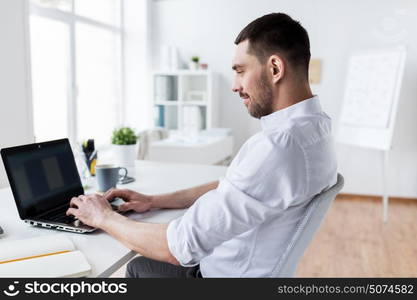 business, people and technology concept - businessman typing on laptop at office. businessman typing on laptop at office