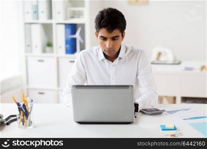 business, people and technology concept - businessman with laptop computer and papers working at office. businessman with laptop working at office
