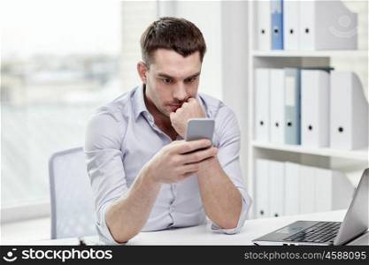 business, people and technology concept - businessman with smartphone and laptop computer at office. businessman with smartphone and laptop at office