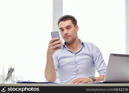 business, people and technology concept - businessman with smartphone and laptop computer at office
