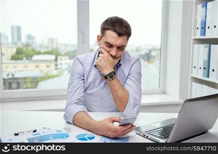 business, people and technology concept - businessman with smartphone and laptop computer at office