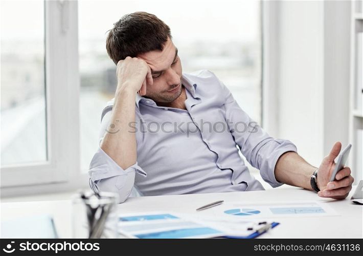 business, people and technology concept - businessman with smartphone and papers at office