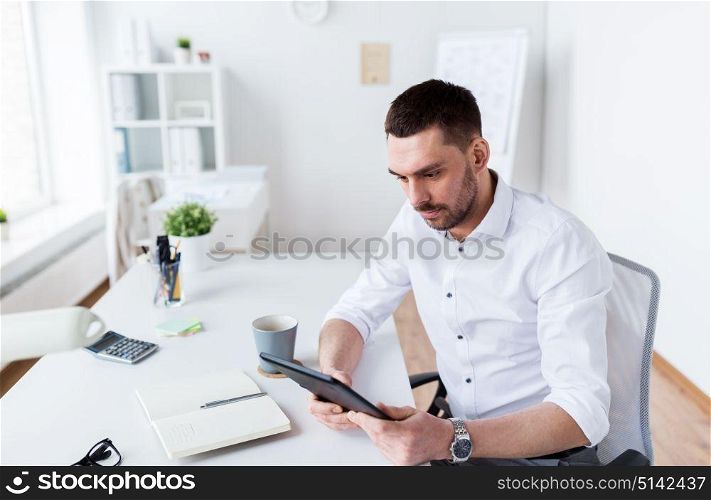 business, people and technology concept - businessman with tablet pc computer at office. businessman with tablet pc at office