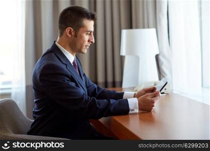 business, people and technology concept - businessman with tablet pc computer working at hotel room. businessman with tablet pc working at hotel room