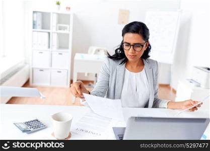 business, people and technology concept - businesswoman with laptop computer and papers working at office. businesswoman with laptop working at office