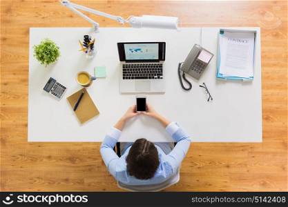 business, people and technology concept - businesswoman with laptop computer and smartphone working at office. businesswoman with laptop and smartphone at office