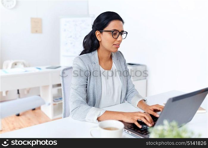 business, people and technology concept - businesswoman with laptop computer working at office. businesswoman with laptop working at office