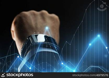 business, people and technology concept - close up of businessman hand with smartwatch and diagram chart virtual projection over black background. close up of businessman hand with smartwatch