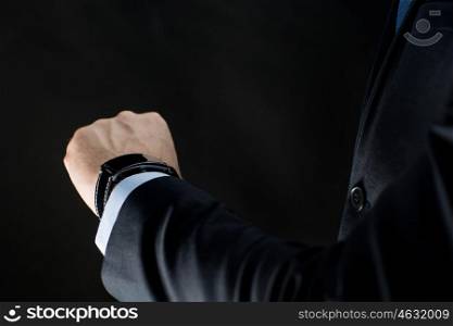 business, people and technology concept - close up of businessman hand with smart watch over black