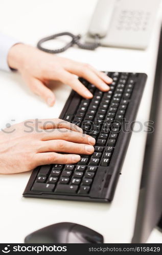 business, people and technology concept - close up of businessman hands typing on computer keyboard at office