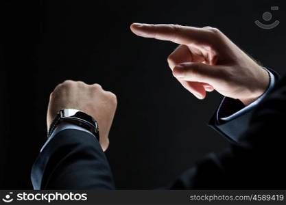business, people and technology concept - close up of businessman hands with smart watch over black