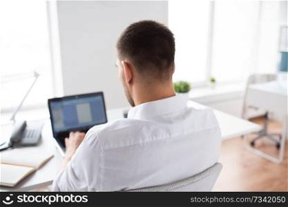 business, people and technology concept - close up of businessman typing on laptop computer at office. close up of businessman typing on laptop at office