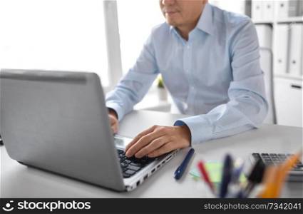 business, people and technology concept - close up of businessman with laptop computer working at office. close up of businessman working with laptop