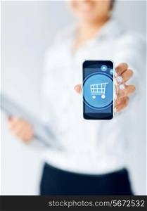 business, people and technology concept - close up of businesswoman showing smartphone screen with shopping trolley icon