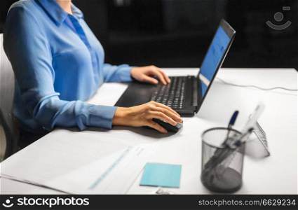 business, people and technology concept - close up of businesswoman using computer mouse for laptop. close up of businesswoman using computer mouse