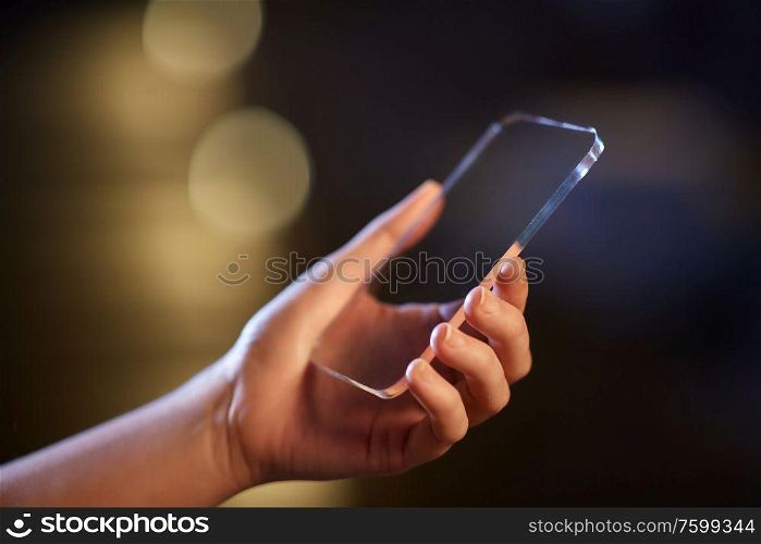 business, people and technology concept - close up of hand with transparent smartphone. close up of hand with transparent smartphone