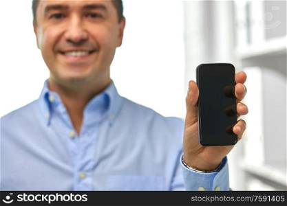 business, people and technology concept - close up of happy smiling businessman showing smartphone black blank screen. happy businessman showing smartphone screen