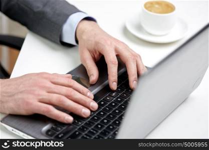 business, people and technology concept - close up of male hands with laptop and coffee cup at office. close up of male hands with laptop and coffee cup