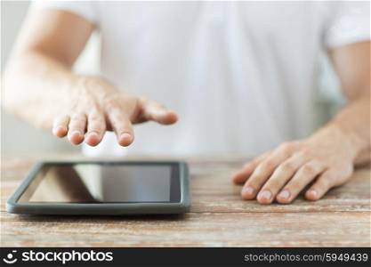 business, people and technology concept - close up of male hands with tablet pc computer on table