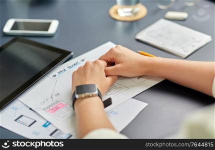 business, people and technology concept - close up of ui designer with mockups working on mobile app design at office. hands with mockup working on ui design at office