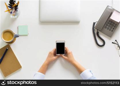 business, people and technology concept - hands of businesswoman with smartphone working at office table. businesswoman with smartphone working at office