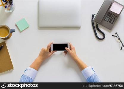 business, people and technology concept - hands of businesswoman with smartphone working at office table. businesswoman with smartphone working at office
