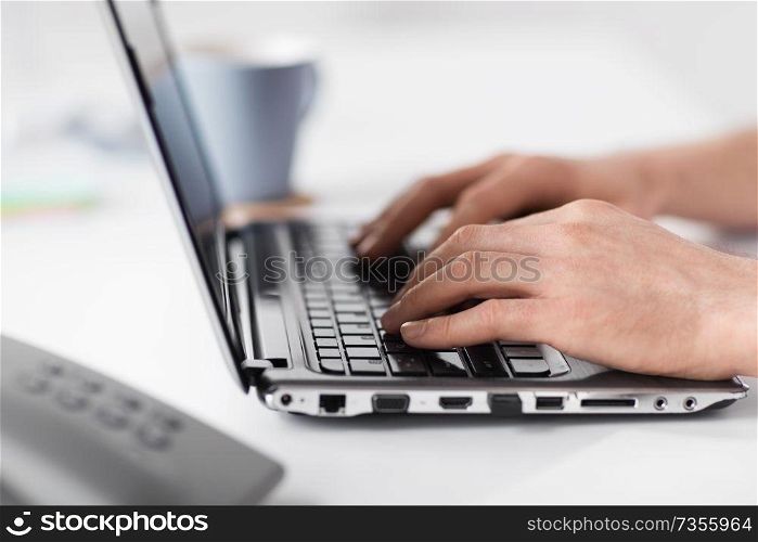 business, people and technology concept - hands typing on laptop computer keyboard at office. hands typing on laptop computer at office