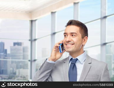 business, people and technology concept -happy businessman calling on smartphone over office room and window with city view background