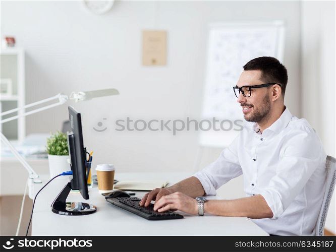 business, people and technology concept - happy businessman in glasses typing on computer keyboard at office. businessman typing on computer keyboard at office