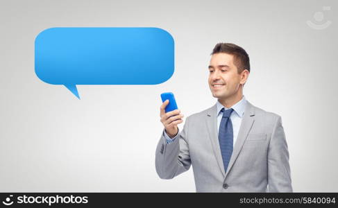 business, people and technology concept - happy businessman texting or reading message on smartphone over messenger text bubble and gray background