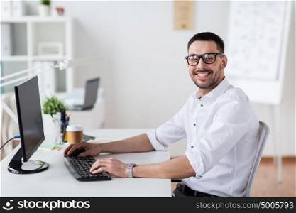 business, people and technology concept - happy businessman typing on computer keyboard at office. businessman typing on computer keyboard at office