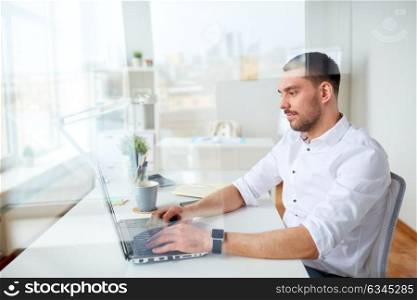 business, people and technology concept - happy businessman typing on laptop computer keyboard at office. happy businessman typing on laptop at office