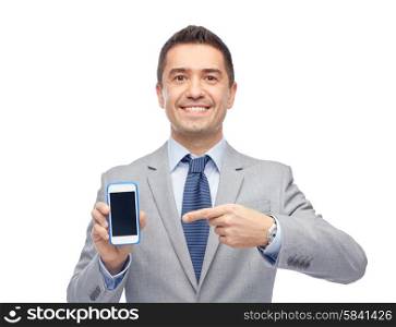business, people and technology concept - happy smiling businessman in suit showing smartphone black blank screen