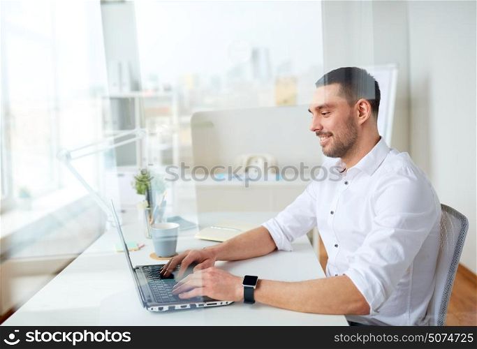 business, people and technology concept - happy smiling businessman typing on laptop computer keyboard at office. happy businessman typing on laptop at office