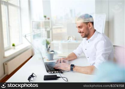 business, people and technology concept - happy smiling businessman typing on laptop computer keyboard at office. happy businessman typing on laptop at office