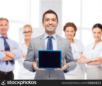 business, people and technology concept - happy smiling businessman with team showing tablet pc computer black blank screen over office room background