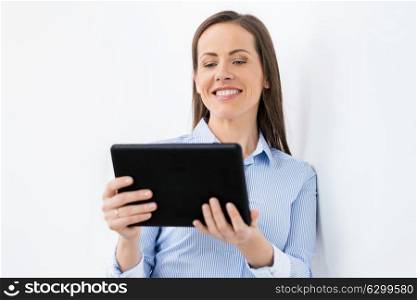 business, people and technology concept - happy smiling businesswoman with tablet pc computer working at office. businesswoman with tablet pc working at office
