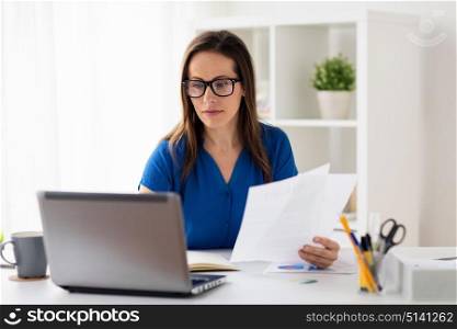 business, people and technology concept - happy smiling woman with laptop computer working at home or office. happy woman with laptop working at home or office
