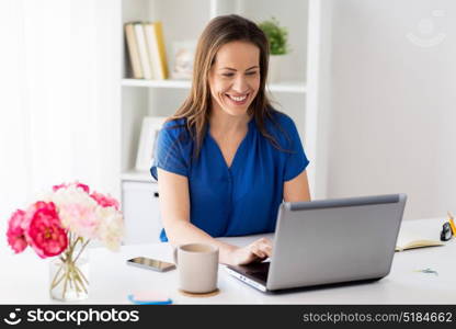 business, people and technology concept - happy smiling woman with laptop computer working at home or office. happy woman with laptop working at home or office