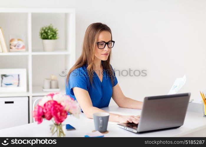 business, people and technology concept - happy smiling woman with laptop computer working at home or office. happy woman with laptop working at home or office