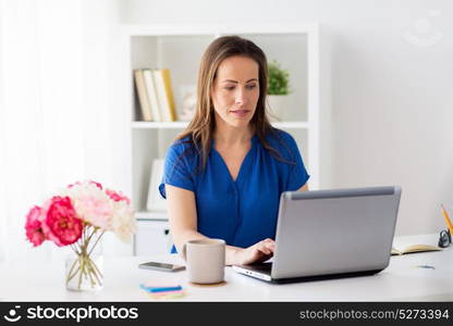 business, people and technology concept - happy smiling woman with laptop computer working at home or office. happy woman with laptop working at home or office