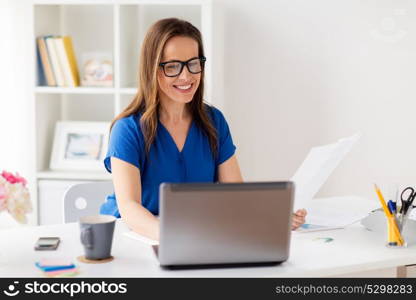 business, people and technology concept - happy smiling woman with laptop computer working at home or office. happy woman with laptop working at home or office