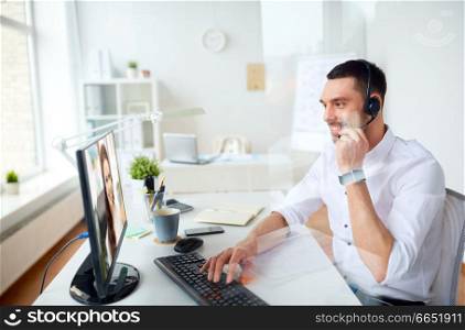 business, people and technology concept - smiling businessman having video call with customer service operator or partner on pc computer at office. businessman having video call on pc at office
