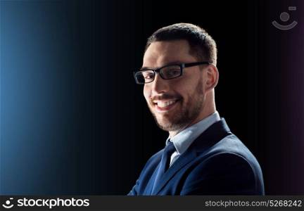 business, people and technology concept - smiling businessman in glasses over black background. smiling businessman in glasses over black