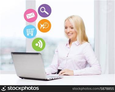 business, people and technology concept - smiling businesswoman or secretary with laptop computer and internet icons in office