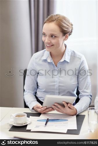 business, people and technology concept - smiling woman with tablet pc computer, papers and cup of coffee in office