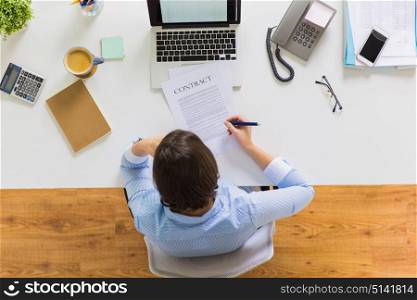 business, people and work concept - businesswoman signing contract document sitting at office table. businesswoman signing contract document at office