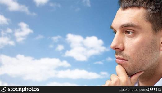 business, people and work concept - close up of businessman face over blue sky and clouds background
