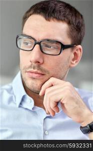 business, people and work concept - portrait of businessman in eyeglasses at office